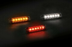 Flache LED Umrissleuchten mit klarem Geh�use, leuchtend in Orange, Wei� und Rot auf dunklem Hintergrund.