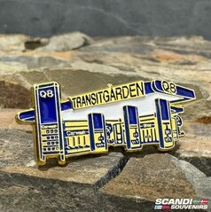 Scandi Pin Transitgarden Fuel: Goldfarbene Anstecknadel mit blau-wei�er Darstellung einer Tankstelle mit Schriftzug "TRANSITGARDEN".